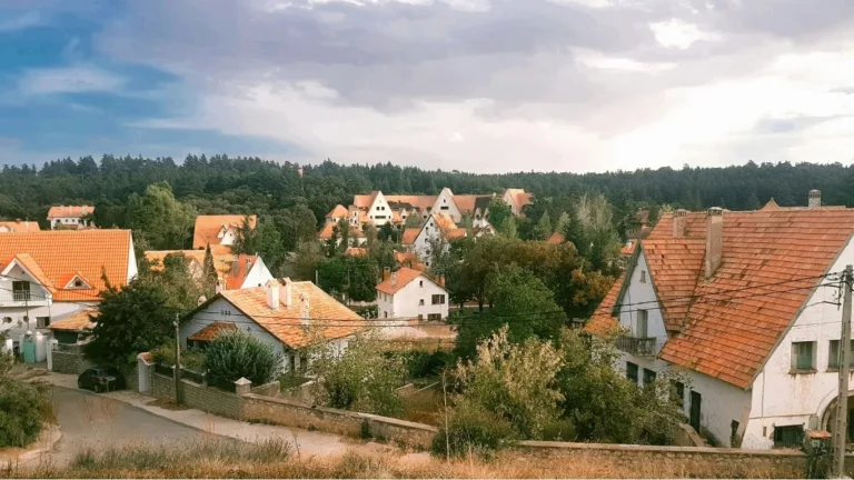 Maisons aux toits de tuiles rouges, nichées au cœur des arbres, dans la ville marocaine d'Ifrane.